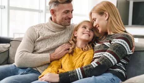 Image of caucasian happy family sitting on sofa together at home